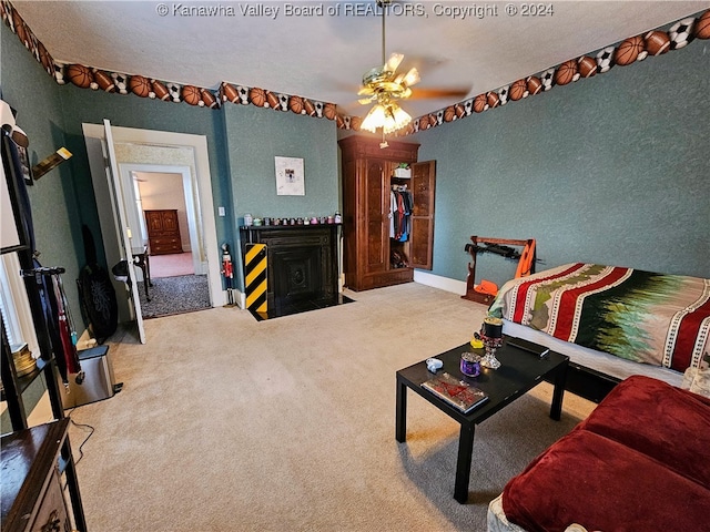 living room featuring ceiling fan, a textured ceiling, and light carpet