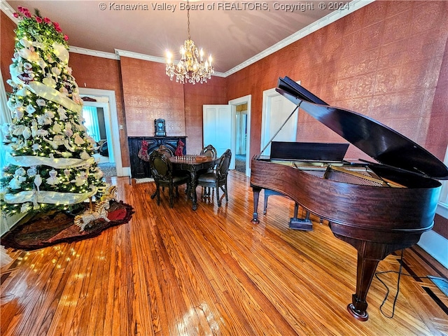 dining space with a notable chandelier, crown molding, and wood-type flooring