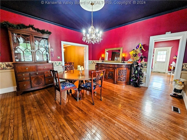 dining area with crown molding, hardwood / wood-style floors, and a chandelier