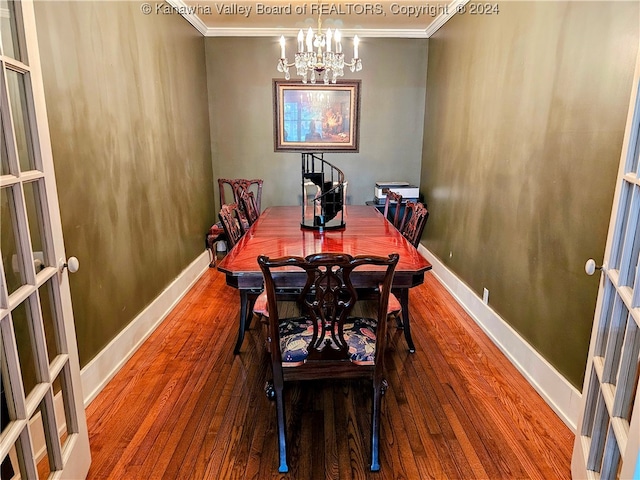 dining area with ornamental molding, an inviting chandelier, and wood-type flooring