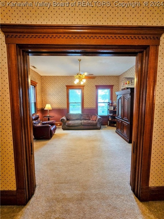 carpeted living room with ceiling fan