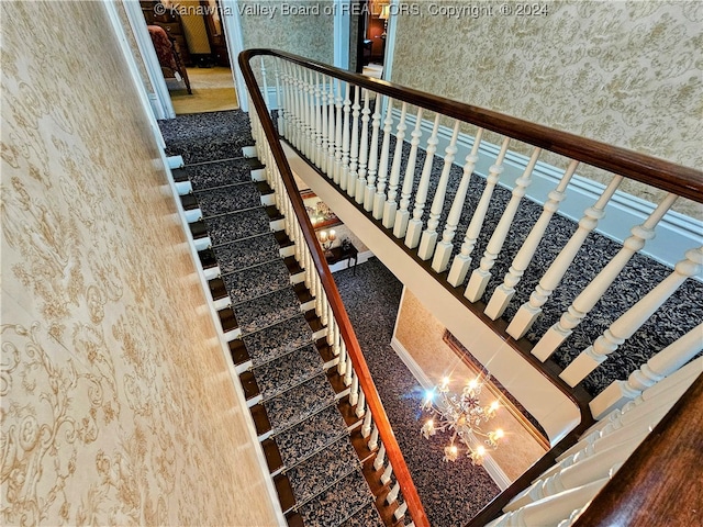 stairway with a high ceiling and a notable chandelier