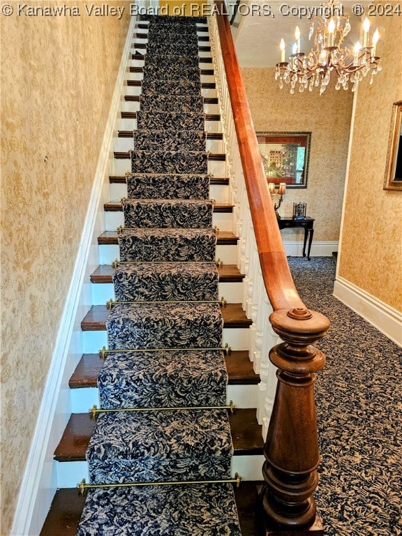 stairway featuring carpet floors and an inviting chandelier