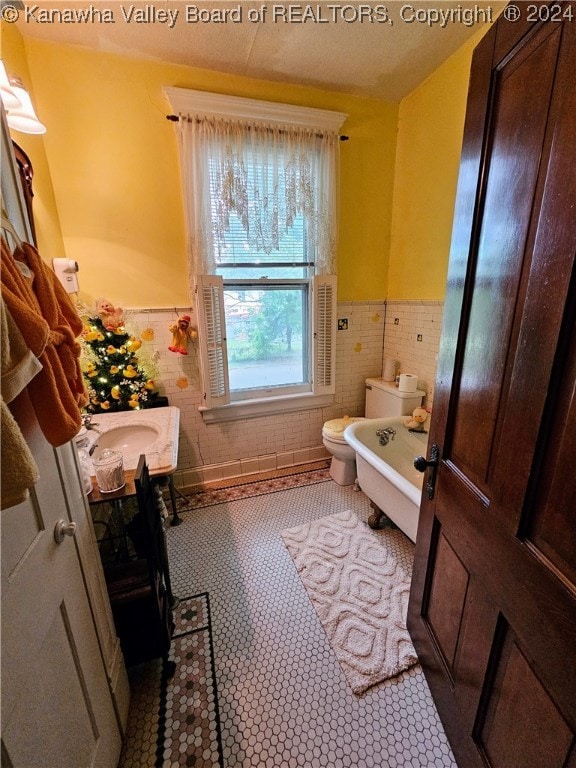 bathroom featuring tile patterned flooring, tile walls, toilet, and vanity