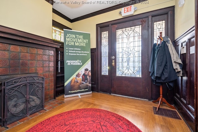 foyer entrance with plenty of natural light, light hardwood / wood-style flooring, and crown molding