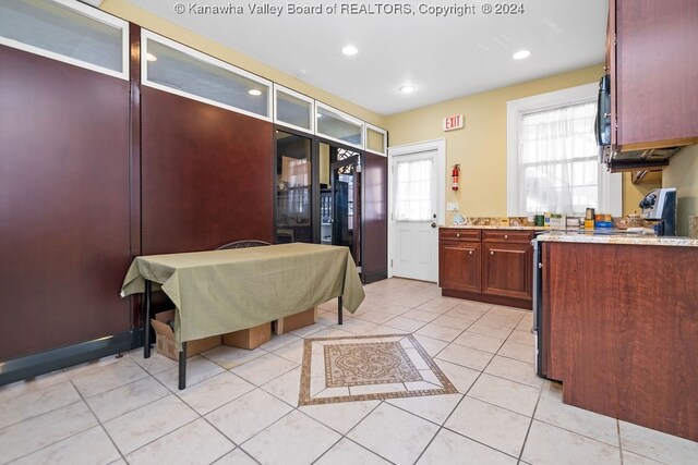 kitchen featuring light tile patterned flooring, white electric range oven, and light stone countertops