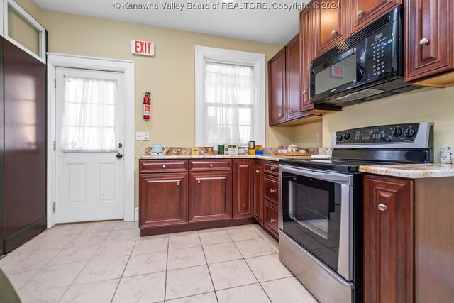 kitchen featuring light stone counters, stainless steel range with electric cooktop, and light tile patterned floors