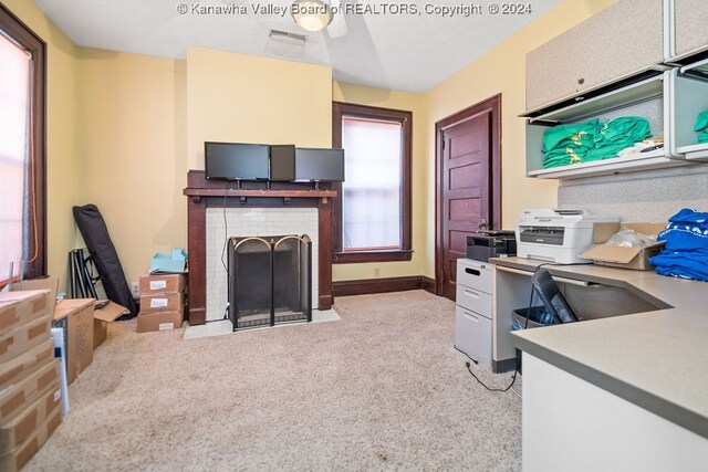 office featuring light colored carpet and a fireplace