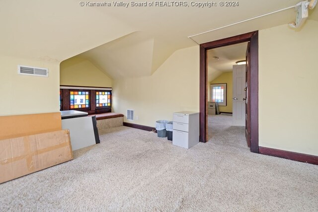 bonus room featuring vaulted ceiling and light carpet