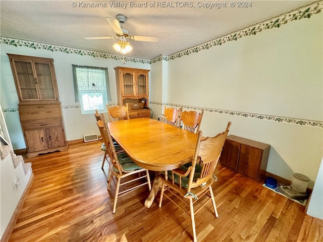 dining space featuring a textured ceiling, ceiling fan, and wood-type flooring