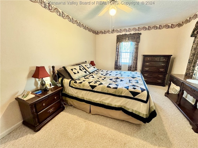 carpeted bedroom with ceiling fan and a textured ceiling