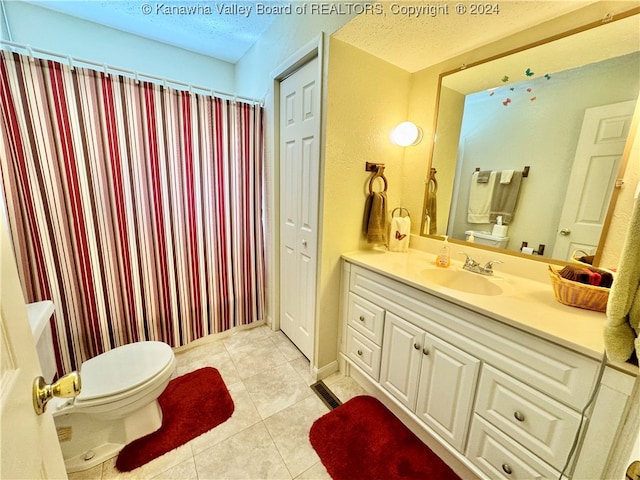 bathroom with toilet, tile patterned flooring, a textured ceiling, and vanity