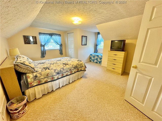 carpeted bedroom featuring a textured ceiling and lofted ceiling