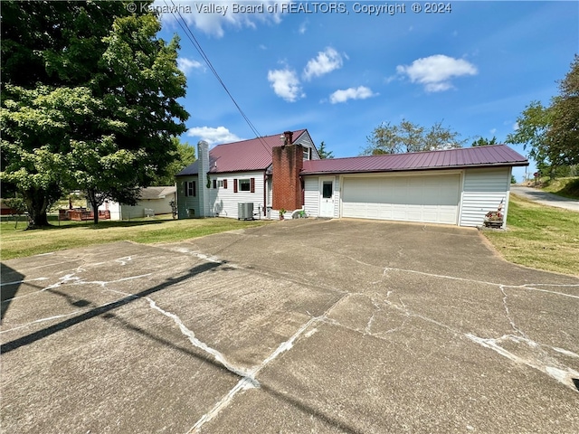 view of front of property featuring a garage and cooling unit