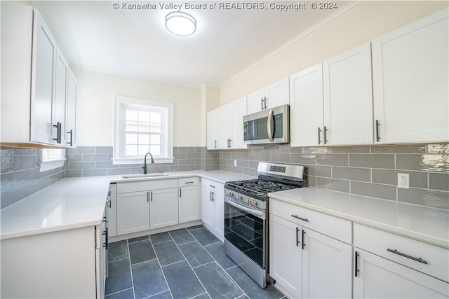 kitchen featuring appliances with stainless steel finishes, white cabinets, and sink