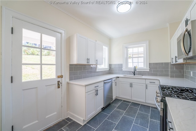 kitchen with a wealth of natural light, sink, tasteful backsplash, and dark tile patterned floors