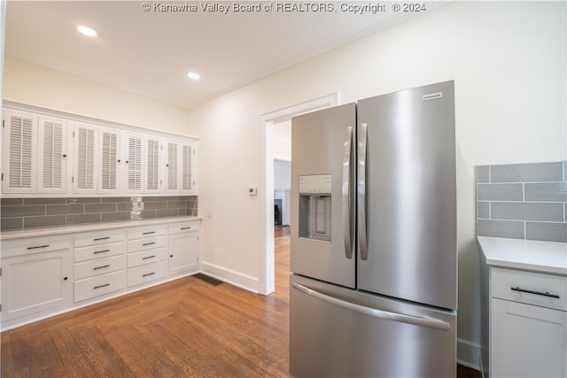 kitchen with stainless steel fridge with ice dispenser, white cabinetry, and tasteful backsplash