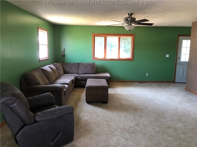 living room featuring ceiling fan, carpet flooring, and a healthy amount of sunlight