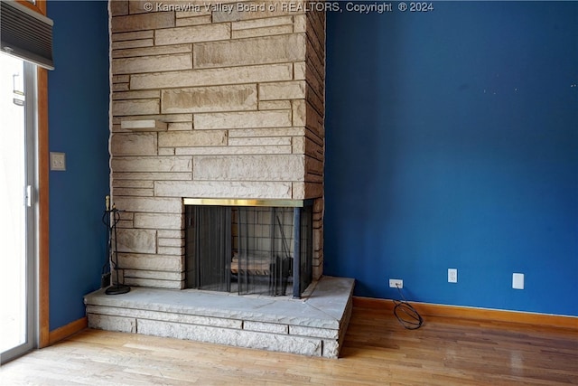 interior details featuring hardwood / wood-style flooring and a stone fireplace