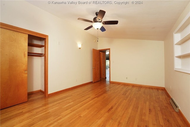 unfurnished bedroom with ceiling fan, a closet, light hardwood / wood-style floors, and lofted ceiling