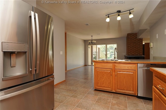 kitchen featuring sink, track lighting, appliances with stainless steel finishes, and light tile patterned flooring