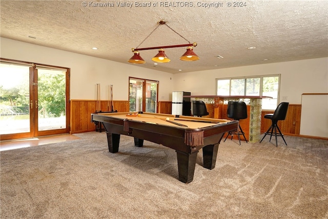 rec room with french doors, pool table, light colored carpet, and a textured ceiling