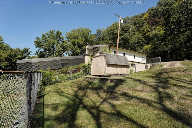 view of side of home featuring a storage unit and a lawn