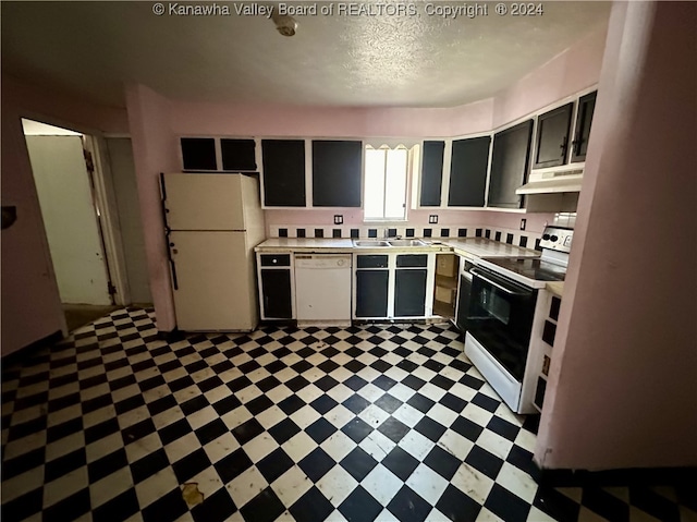 kitchen with sink, a textured ceiling, white appliances, and dark tile patterned floors