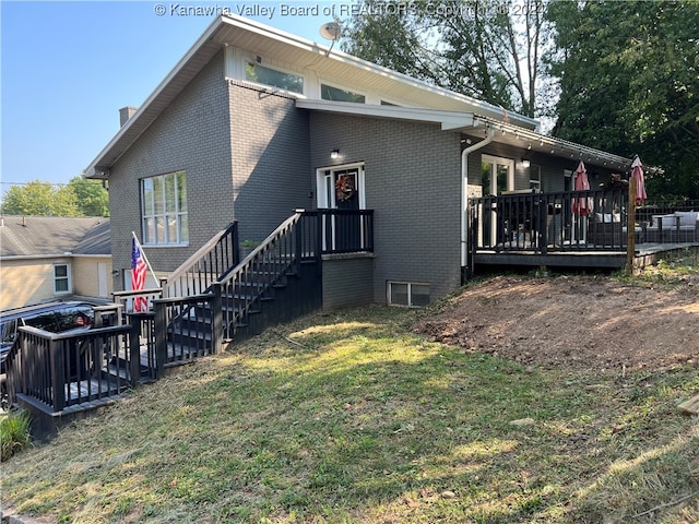 exterior space with a deck and a lawn