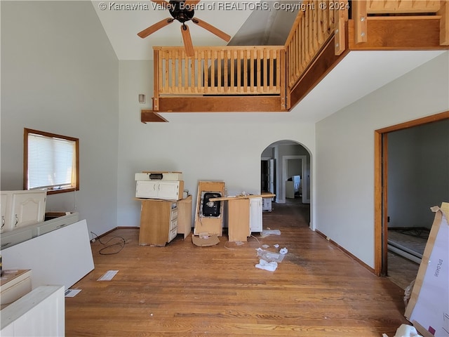 dining space with hardwood / wood-style flooring, high vaulted ceiling, and ceiling fan