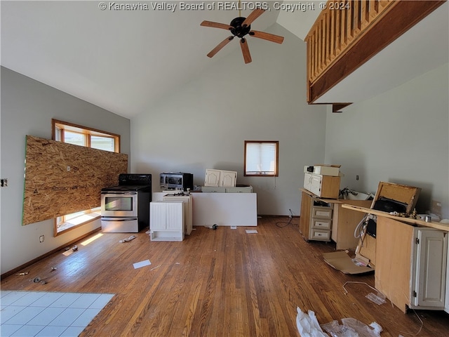 unfurnished office with hardwood / wood-style floors, high vaulted ceiling, and a wealth of natural light