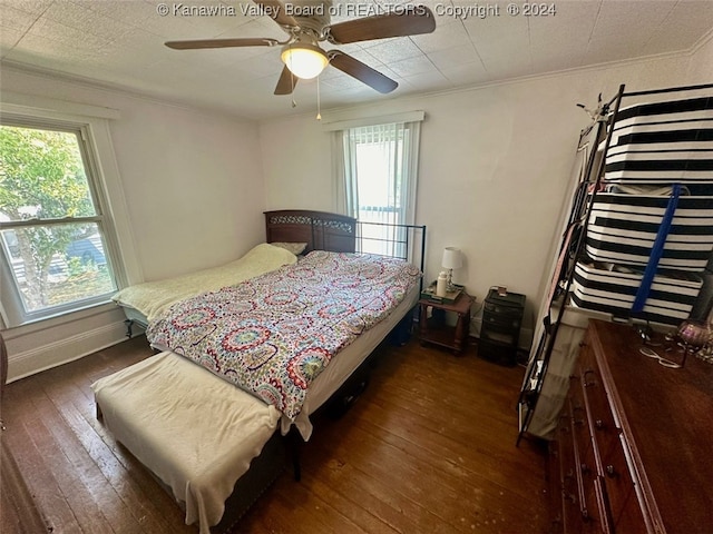 bedroom with crown molding, ceiling fan, and dark hardwood / wood-style floors