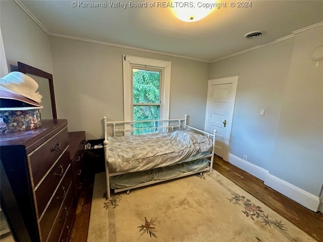 bedroom featuring ornamental molding and hardwood / wood-style floors