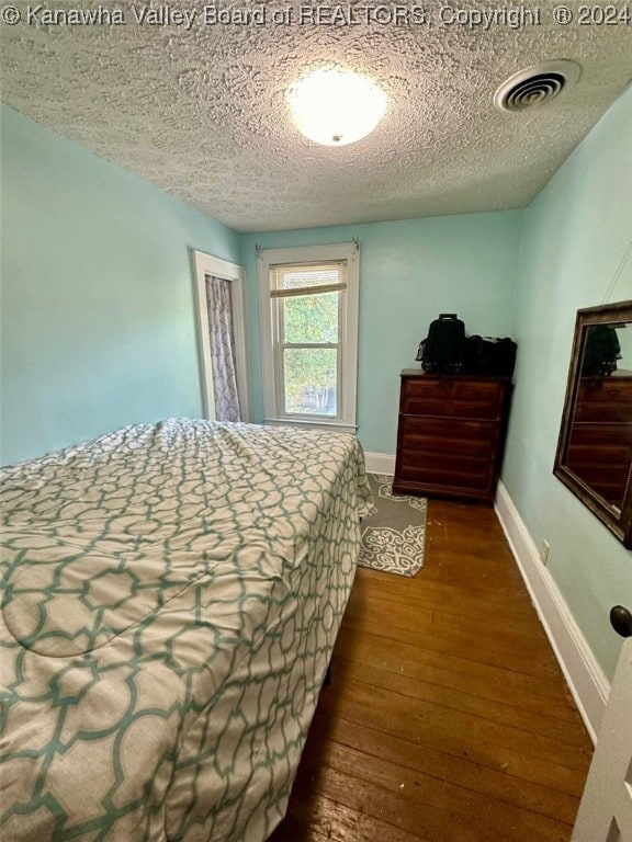 bedroom featuring a textured ceiling and hardwood / wood-style flooring