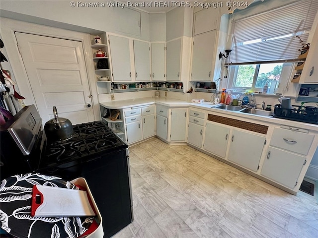 kitchen featuring white cabinetry, black gas stove, and sink