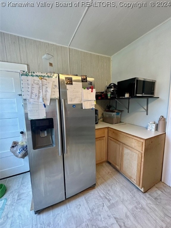 kitchen with wood walls and stainless steel fridge