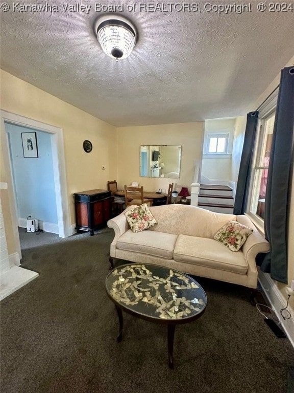 carpeted living room featuring a textured ceiling