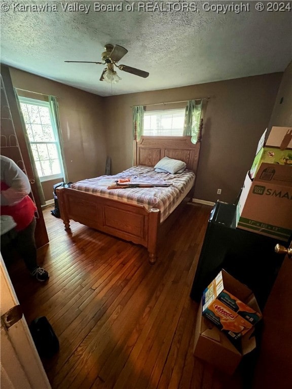 bedroom featuring hardwood / wood-style floors, ceiling fan, and a textured ceiling