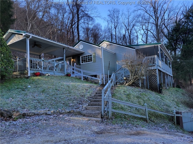 view of front facade featuring ceiling fan and a wooden deck