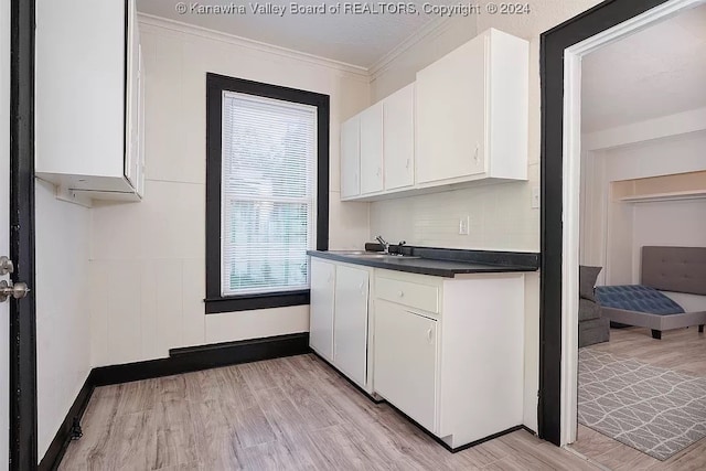 kitchen with white cabinets, light hardwood / wood-style floors, and crown molding