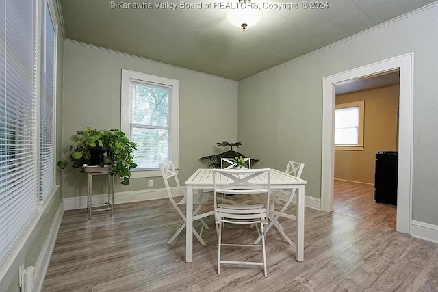 dining area featuring ornamental molding and wood-type flooring