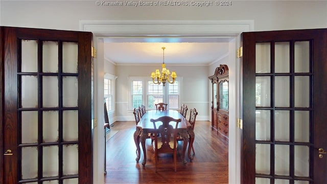 dining space featuring crown molding, wood-type flooring, and an inviting chandelier