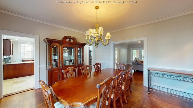 dining space with ornamental molding, a wealth of natural light, and a chandelier