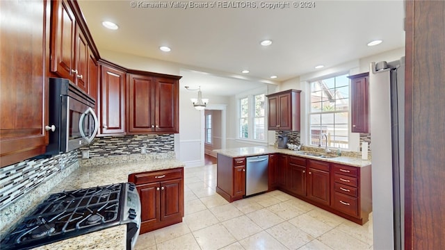 kitchen with light stone countertops, tasteful backsplash, stainless steel appliances, sink, and hanging light fixtures