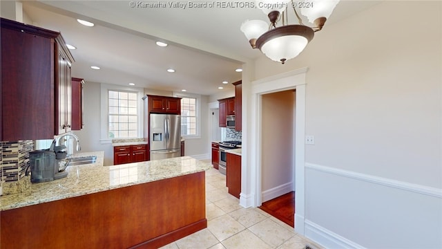 kitchen with sink, kitchen peninsula, stainless steel appliances, and tasteful backsplash