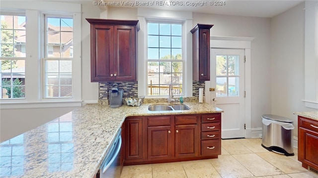 kitchen with decorative backsplash, sink, stainless steel dishwasher, and light stone counters