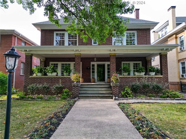 view of front of property with covered porch and a front yard