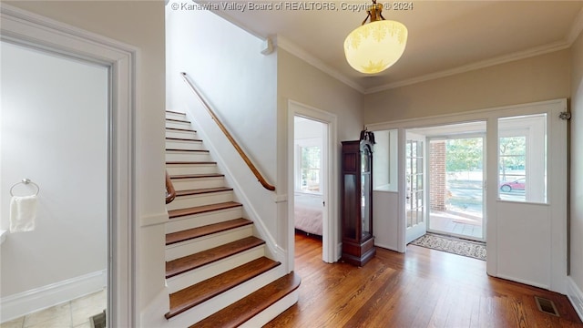 foyer featuring wood-type flooring and ornamental molding