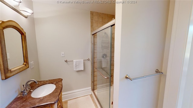 bathroom featuring tile patterned flooring, vanity, and a shower with door