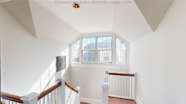 stairway with hardwood / wood-style flooring and vaulted ceiling